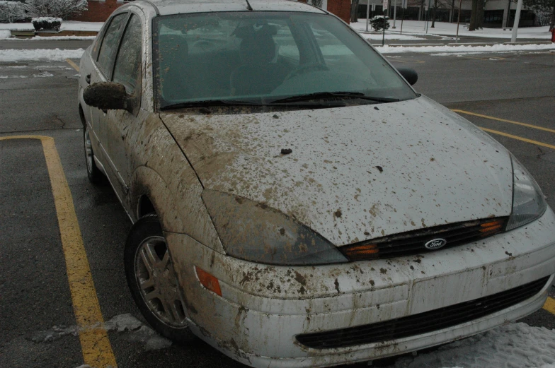 a dirty white car that has some dirt on it