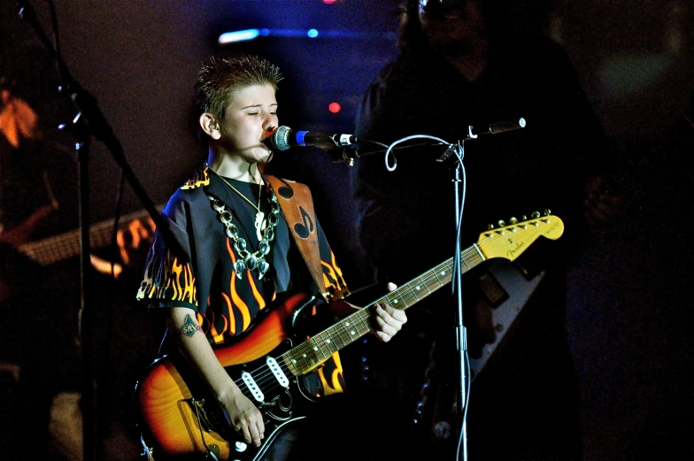 a person playing a guitar in front of a microphone