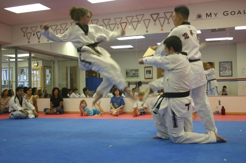 two boys are performing martial tricks at an indoor competition