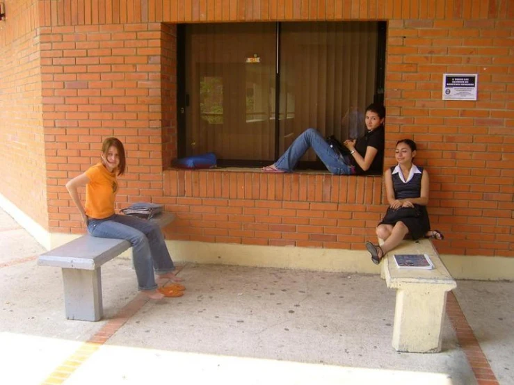 three women sit and sit on bench next to a window