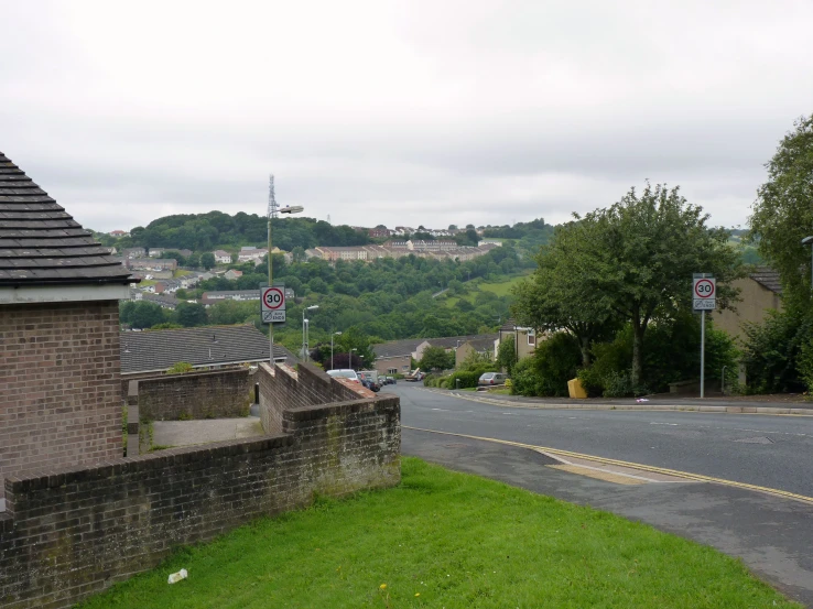 some signs on a corner with a view of town