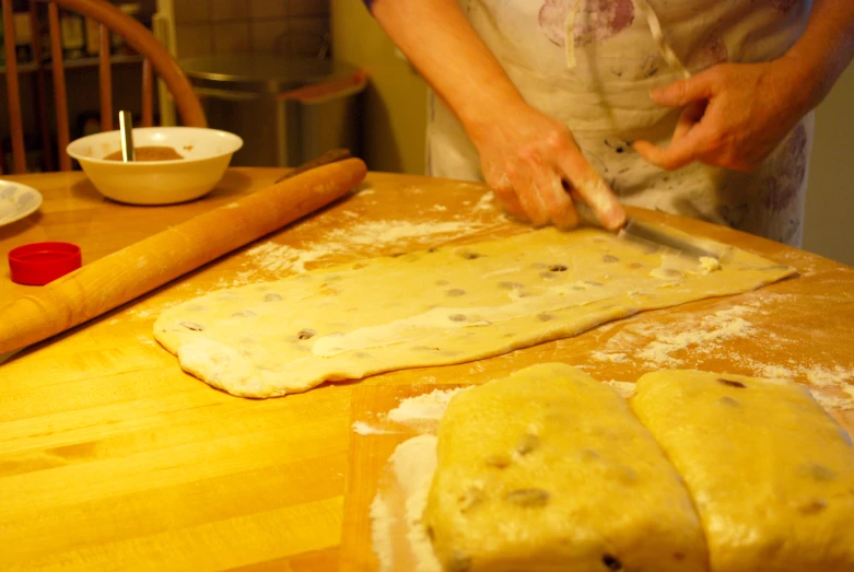 a person using scissors to cut a dough