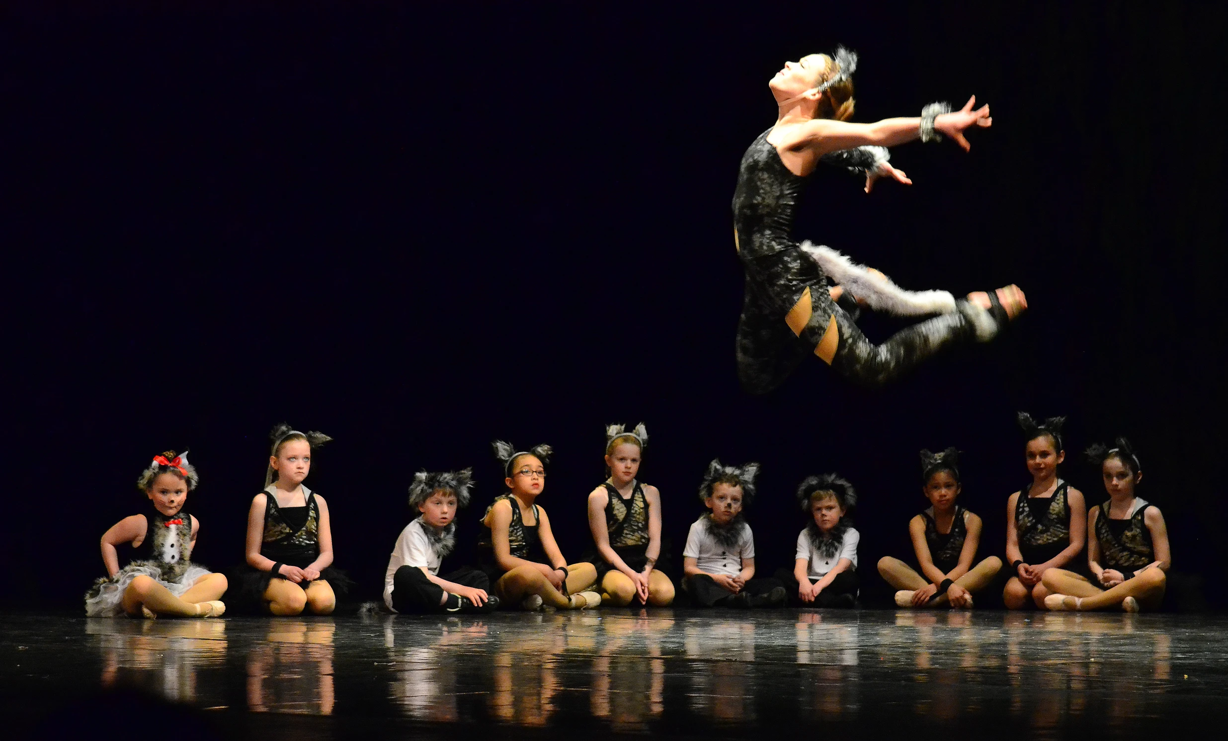 a girl is in the air over several children