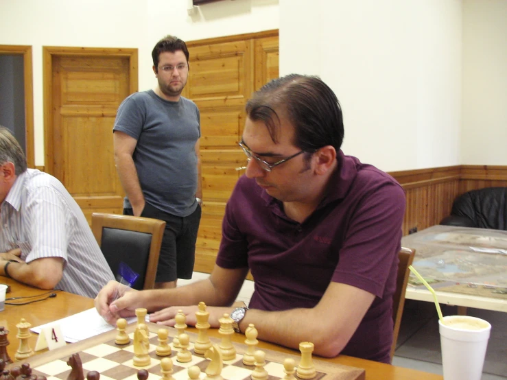 men play chess together in an office