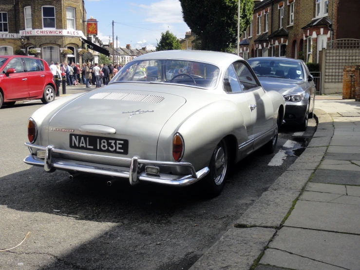 an old, silver car is parked next to a red and white car