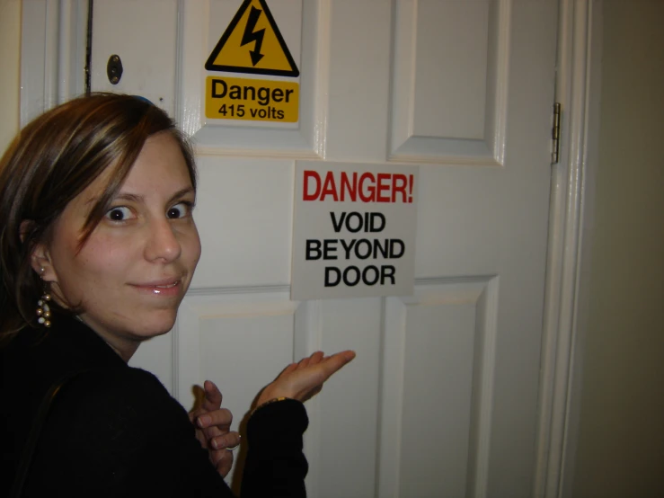 a woman pointing in front of danger signs