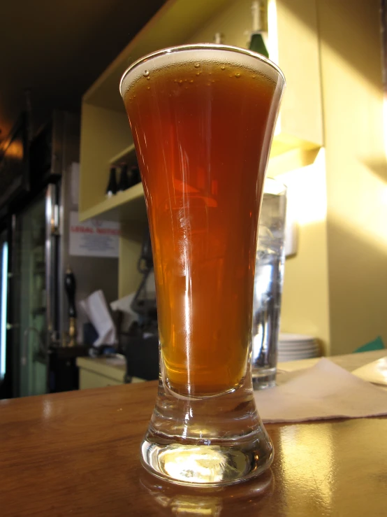 a beer is sitting in a glass on the table