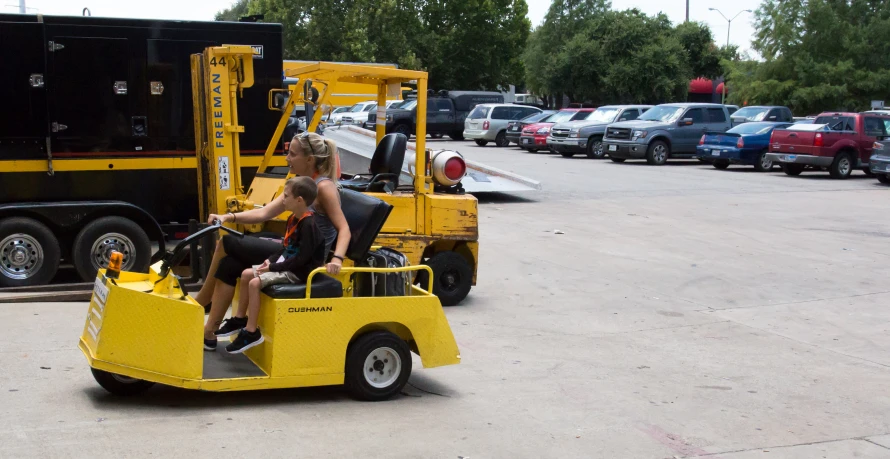 people sitting in the cab of a yellow vehicle