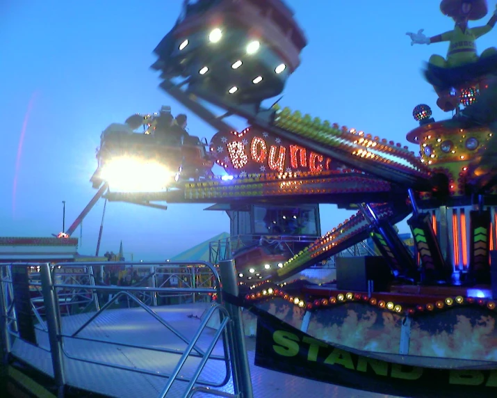 a carnival rides on a blue lit sky background
