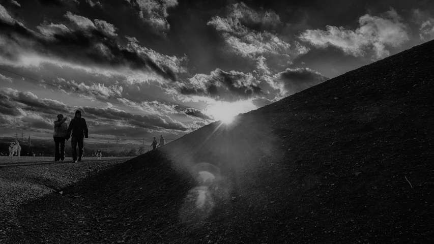 people walking down a road with the sun shining down