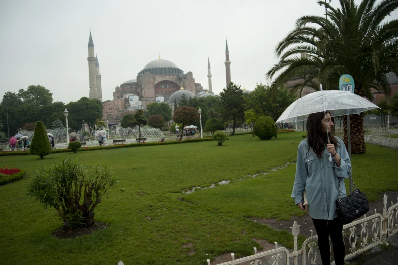 a woman with an umbrella in front of a large building