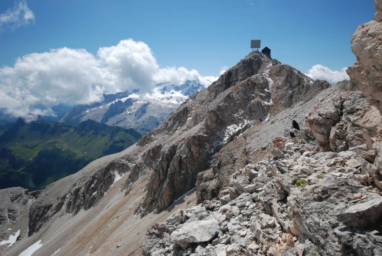 a mountain view with clouds, rocks and hills in the distance