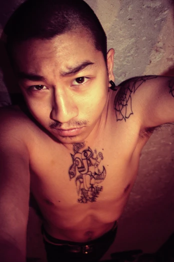 an asian male with very large and small tattoos
