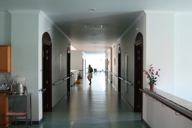 the hallway at a hospital with people standing at the end