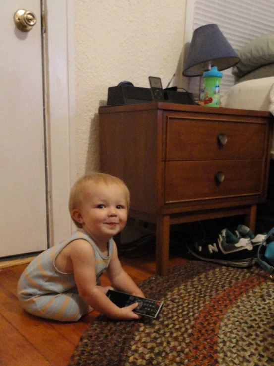 a child playing on the floor with a remote control