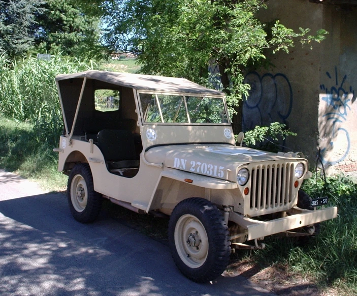 a vintage jeep in the shade of a tree