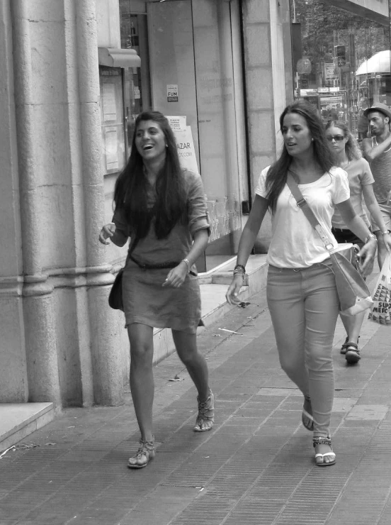 some beautiful young women walking down the sidewalk