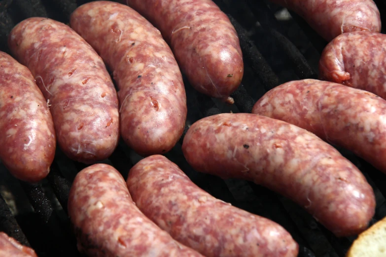 large pieces of sausages are cooking on a grill