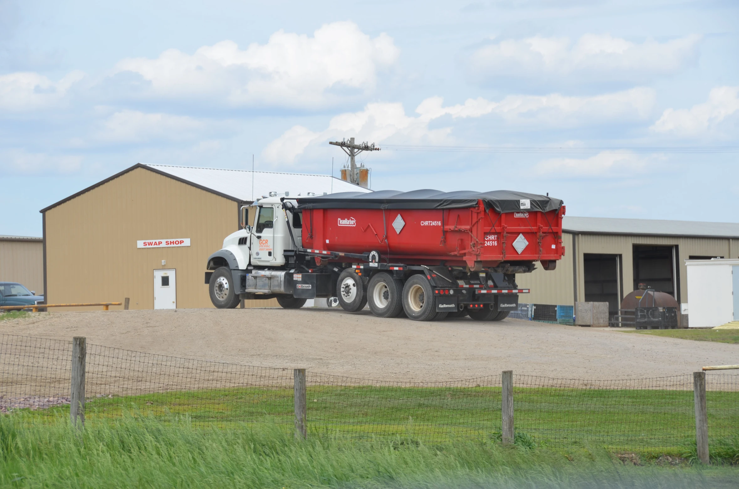 a truck carrying a load through a rural area