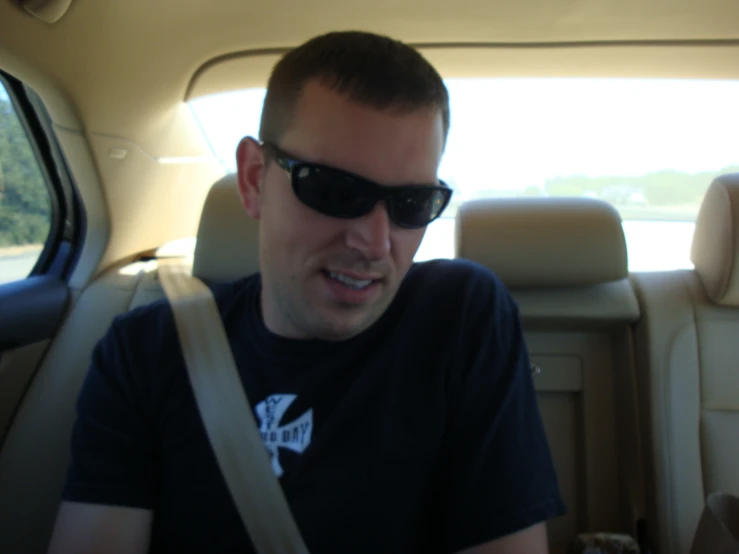 a man wearing sunglasses looking into a car