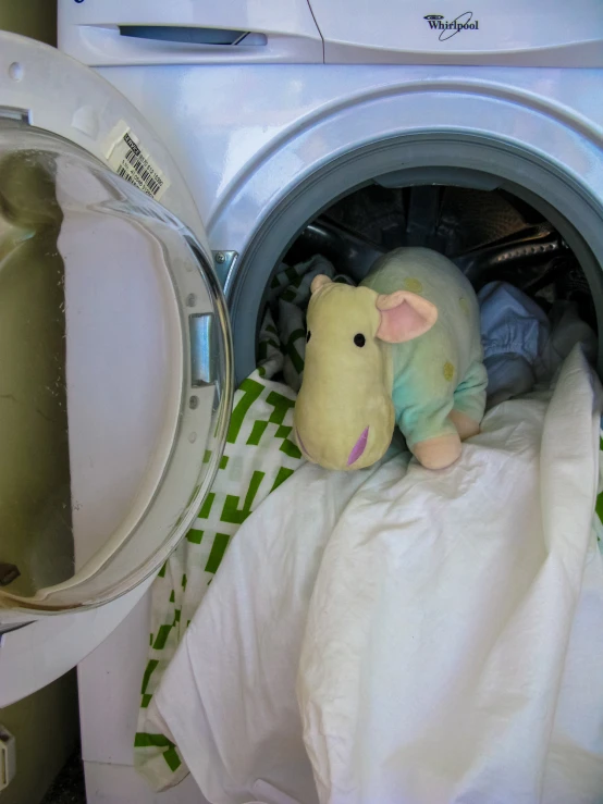 a stuffed toy animal is sitting inside a dryer