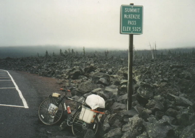 a bicycle next to a sign in a parking lot