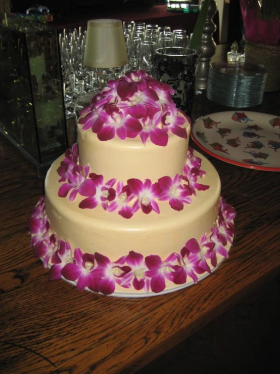 a multi layer cake decorated with purple orchids