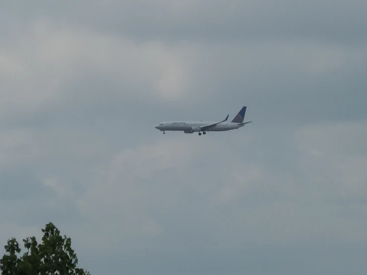 a large airplane flying in the sky on an overcast day