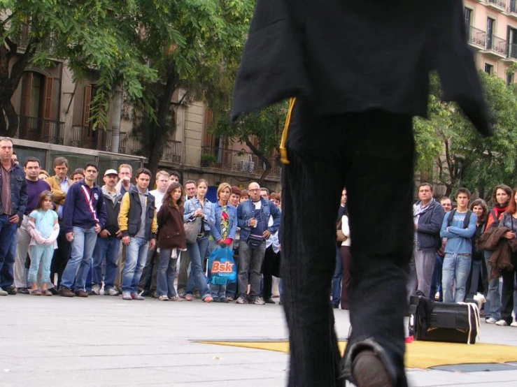 people standing on the sidewalk watching a man with a suitcase