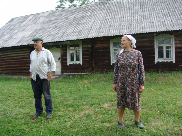 the woman and man are in front of a building