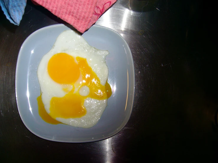 the egg is sitting on top of an empty plate