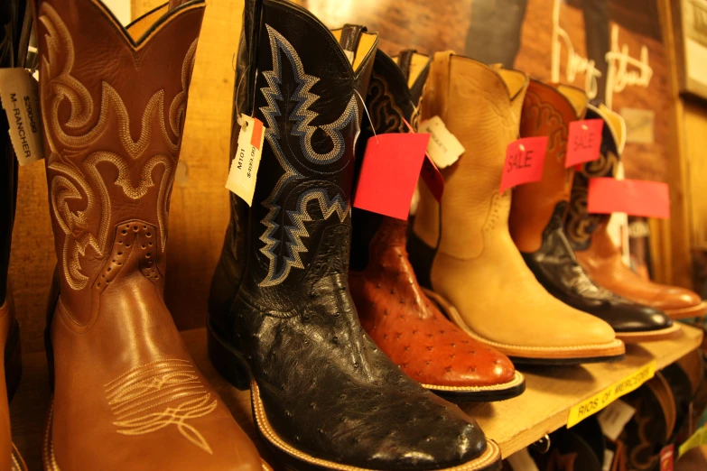 cowboy boots lined up against a wooden shelf