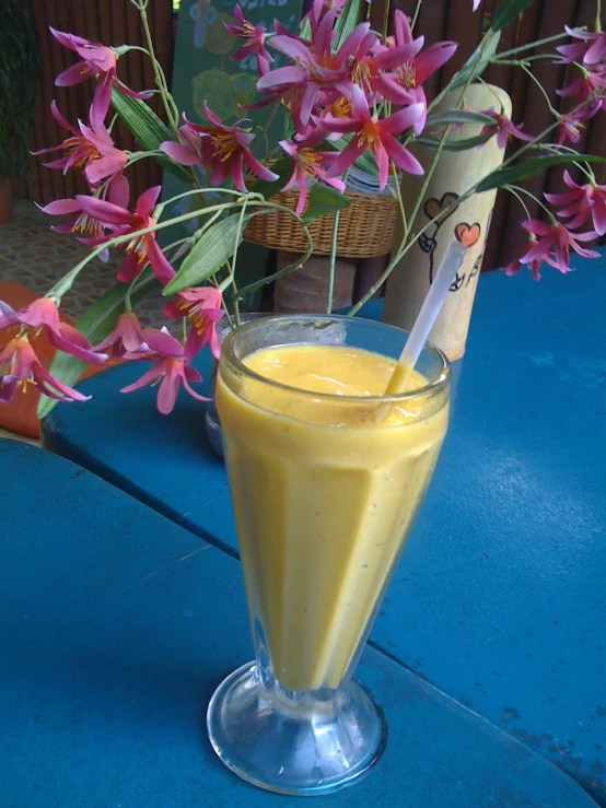 a drink glass with some flowers and a straw