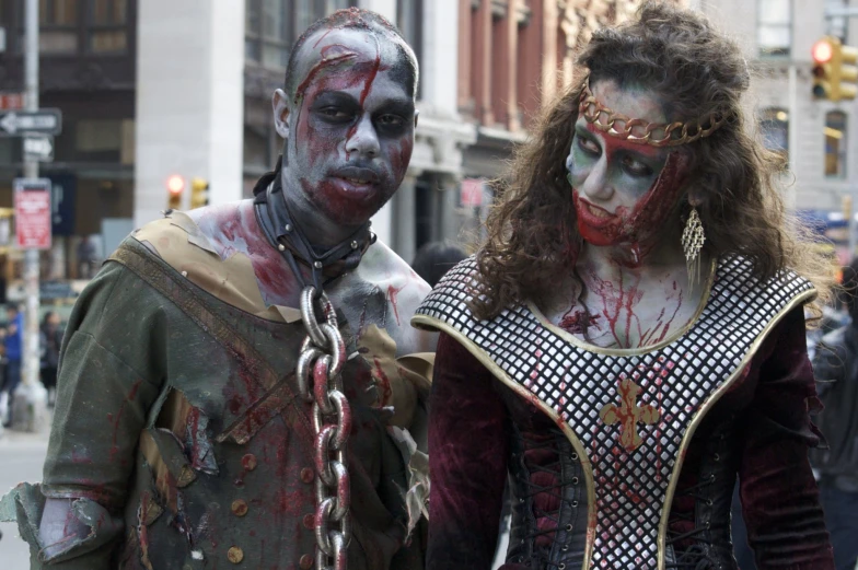 two people dressed as zombies walking down a city street