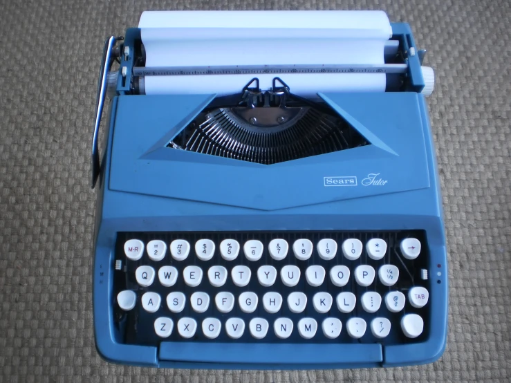 a blue typewriter on a carpet in a room