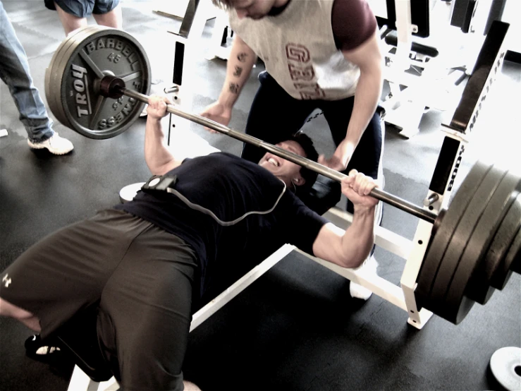 two men working their body with weights in a gym