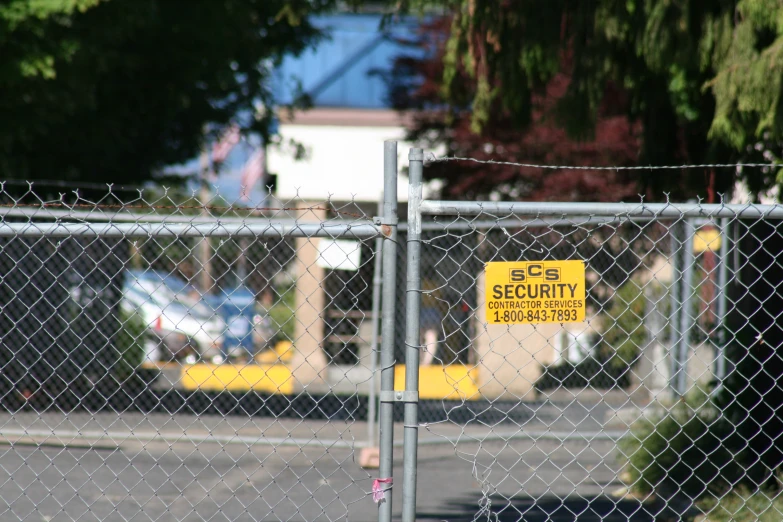 a security sign mounted on a chain link fence