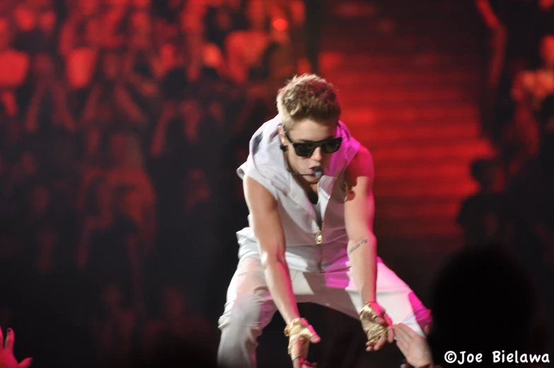 singer in costume, performing on stage with audience behind him