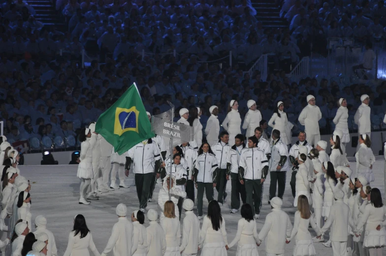 a crowd of people wearing coats, white clothes and green caps