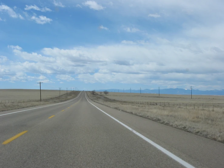 long straight open road with some telephone poles on each side