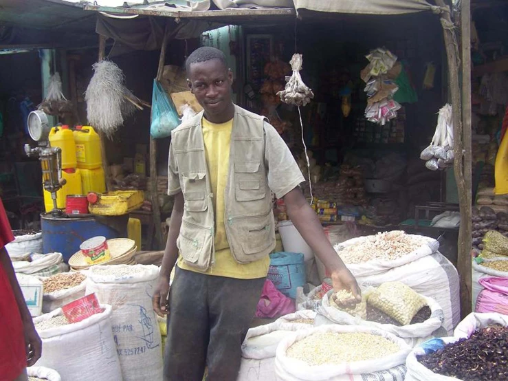 a man smiles while standing next to bags with cereal