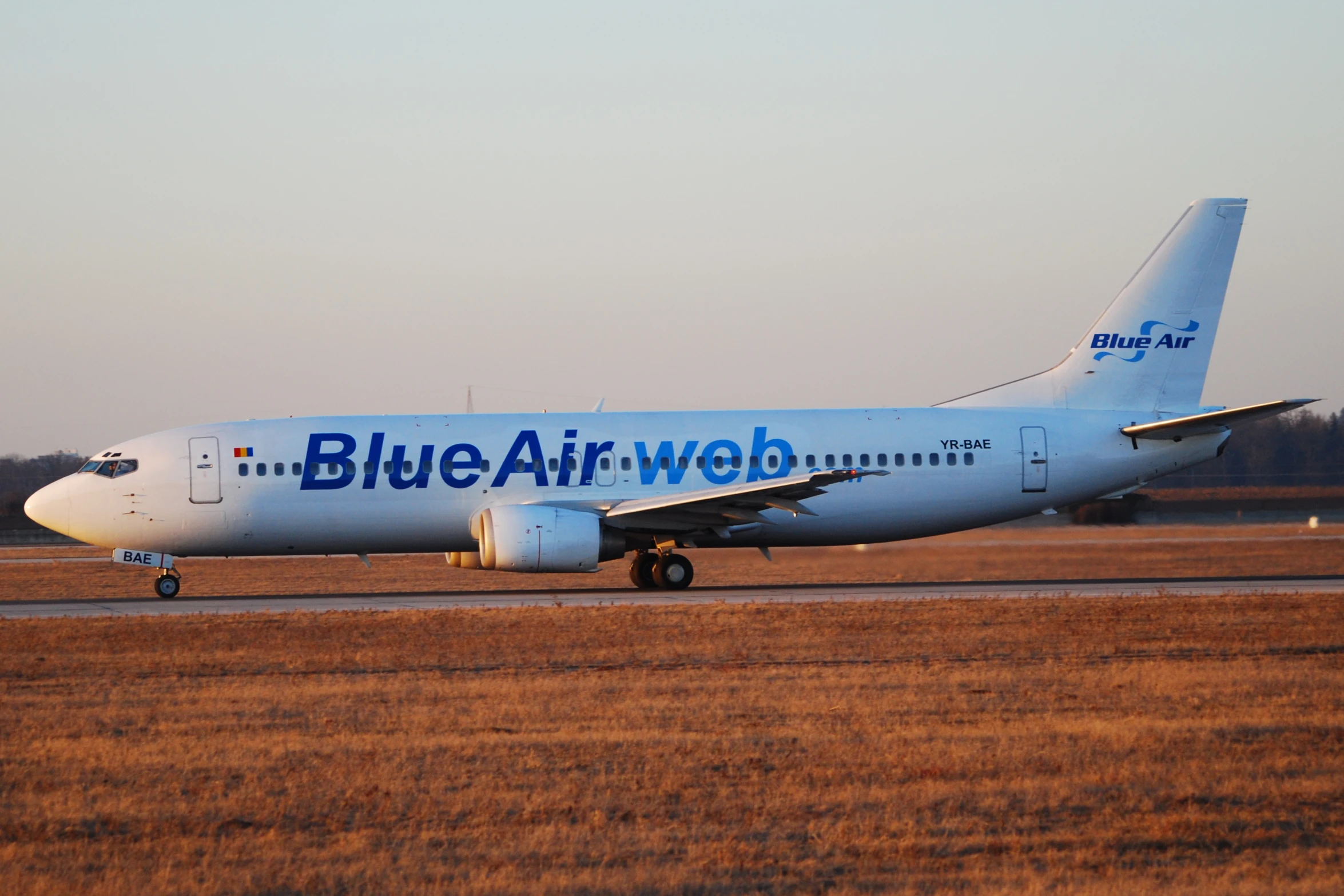 a blue airwave passenger plane on an airport runway