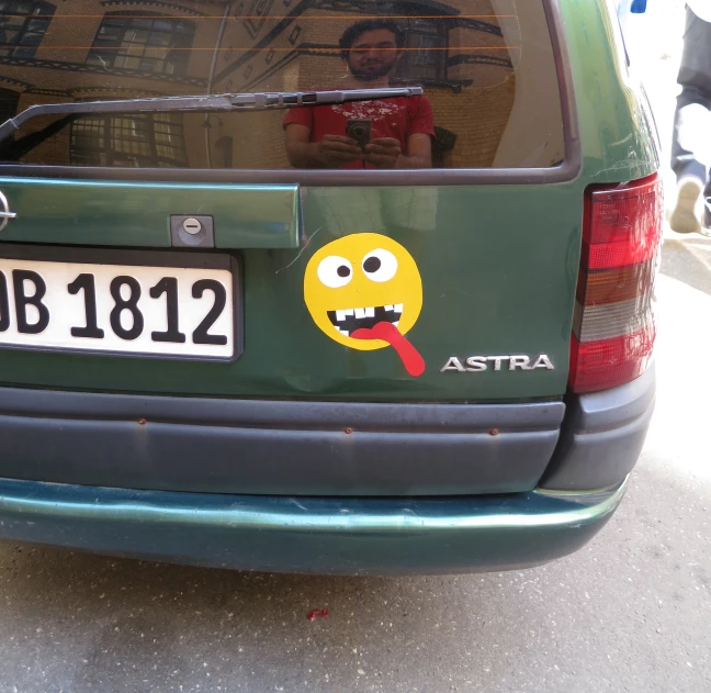 a green car with a cartoon face painted on it's side