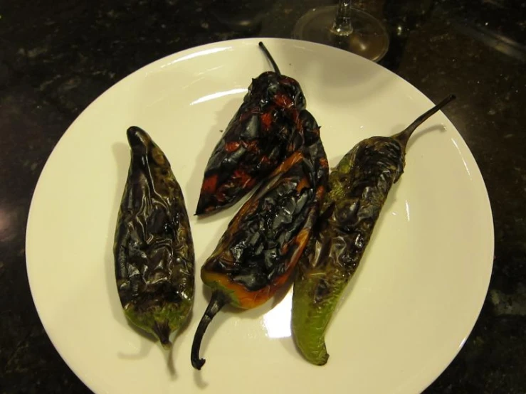 some small chilli peppers are sitting on a plate