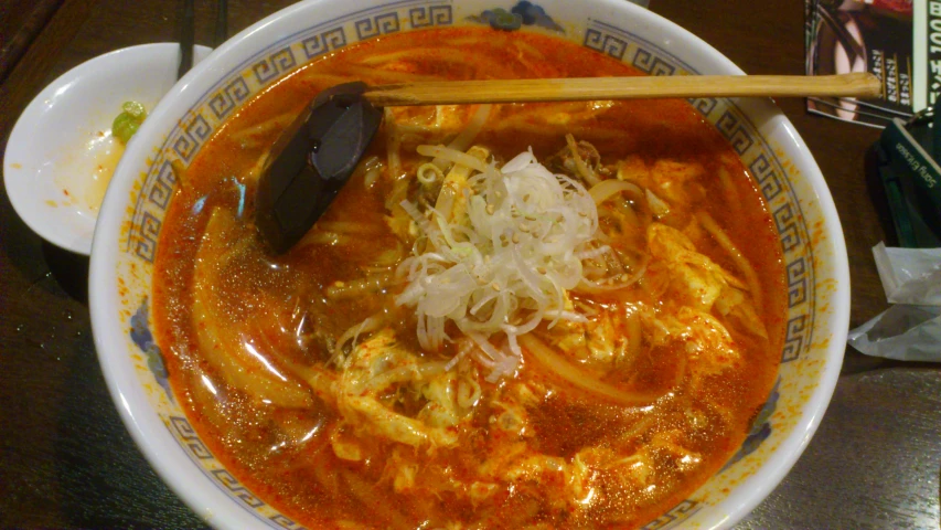 a bowl with soup and spoons in it