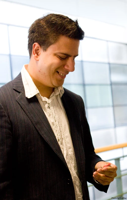 a close up of a person wearing a suit and smiling