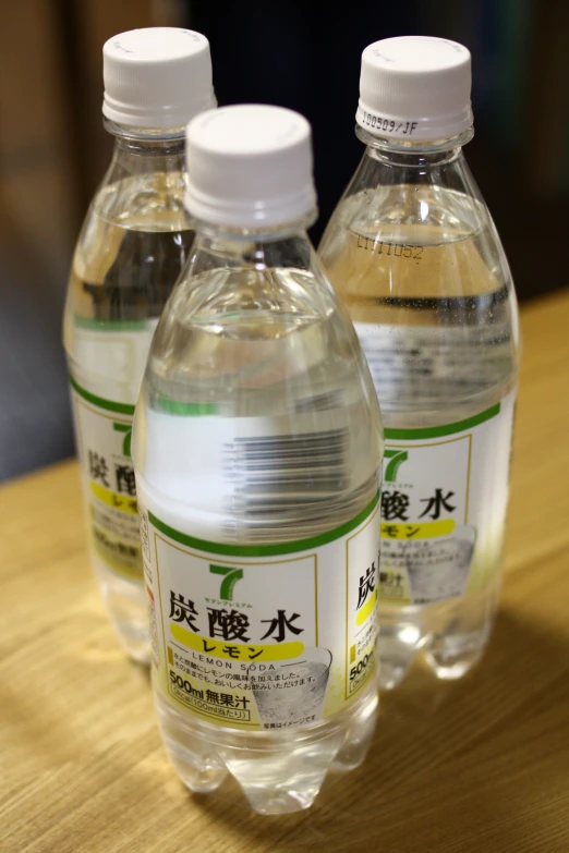 three clear water bottles with asian writing on them