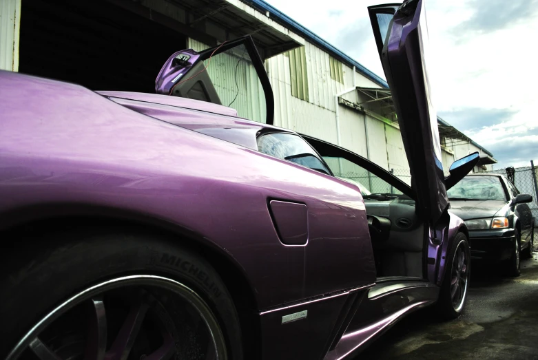 a purple sports car that is parked near a building