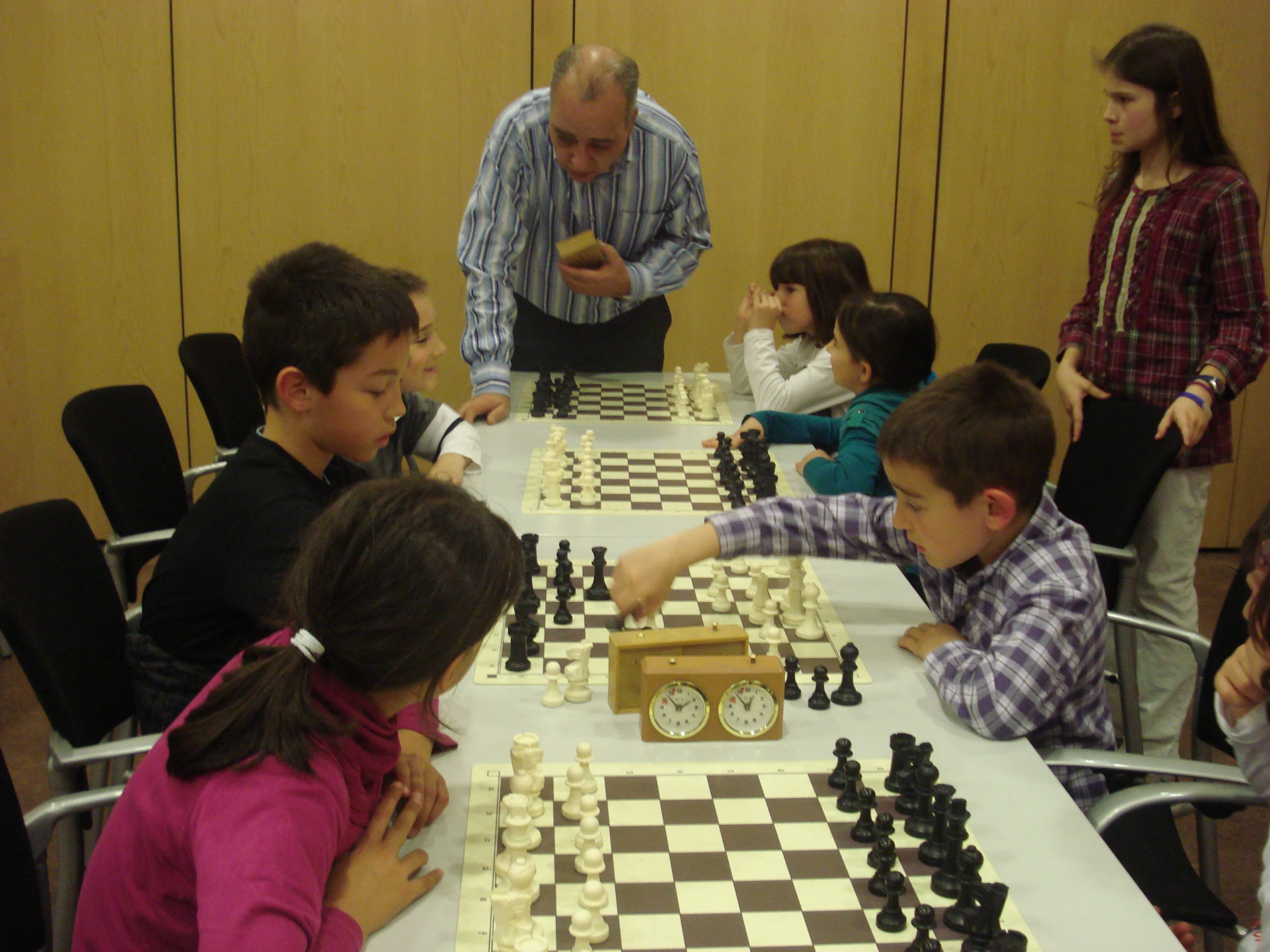 a group of s sitting around a table playing chess