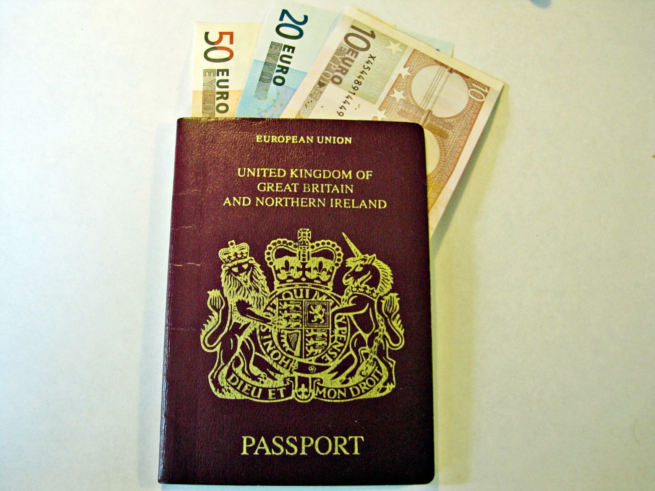 a passport and five pound notes sitting on top of each other